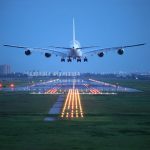 Uma foto aérea do Aeroporto Internacional de Guarulhos, com aviões decolando e pousando em um dia ensolarado.